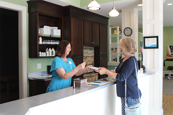 Patient checking in at the Strand Spine Institute front desk
